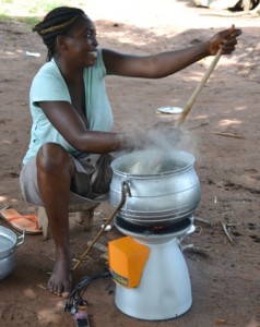 Ghanéenne cuisinant tout en rechargeant son téléphone portable