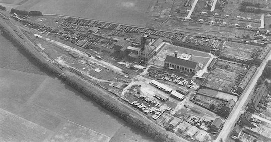 La chaufferie, aujourd'hui au coeur de la ville, a été installée sur le site de l'ancienne Fosse 14 de Lens, fermée en 1967 et à l'époque encore entourée de cultures