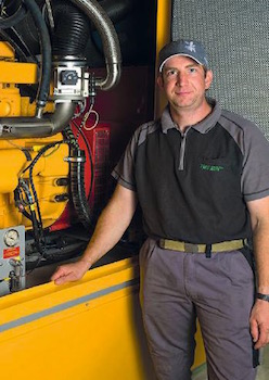 Simon Eschler, Agri Bio Val SA, devant la génératrice au biogaz, photo Aide Suisse aux Montagnards